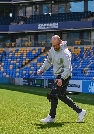 Banana Swift filming football event content on the pitch at AFC Wimbledon